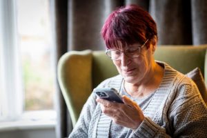 Ageing-Better-Lady-using-phone-at-home-digital-technology-900x600-1